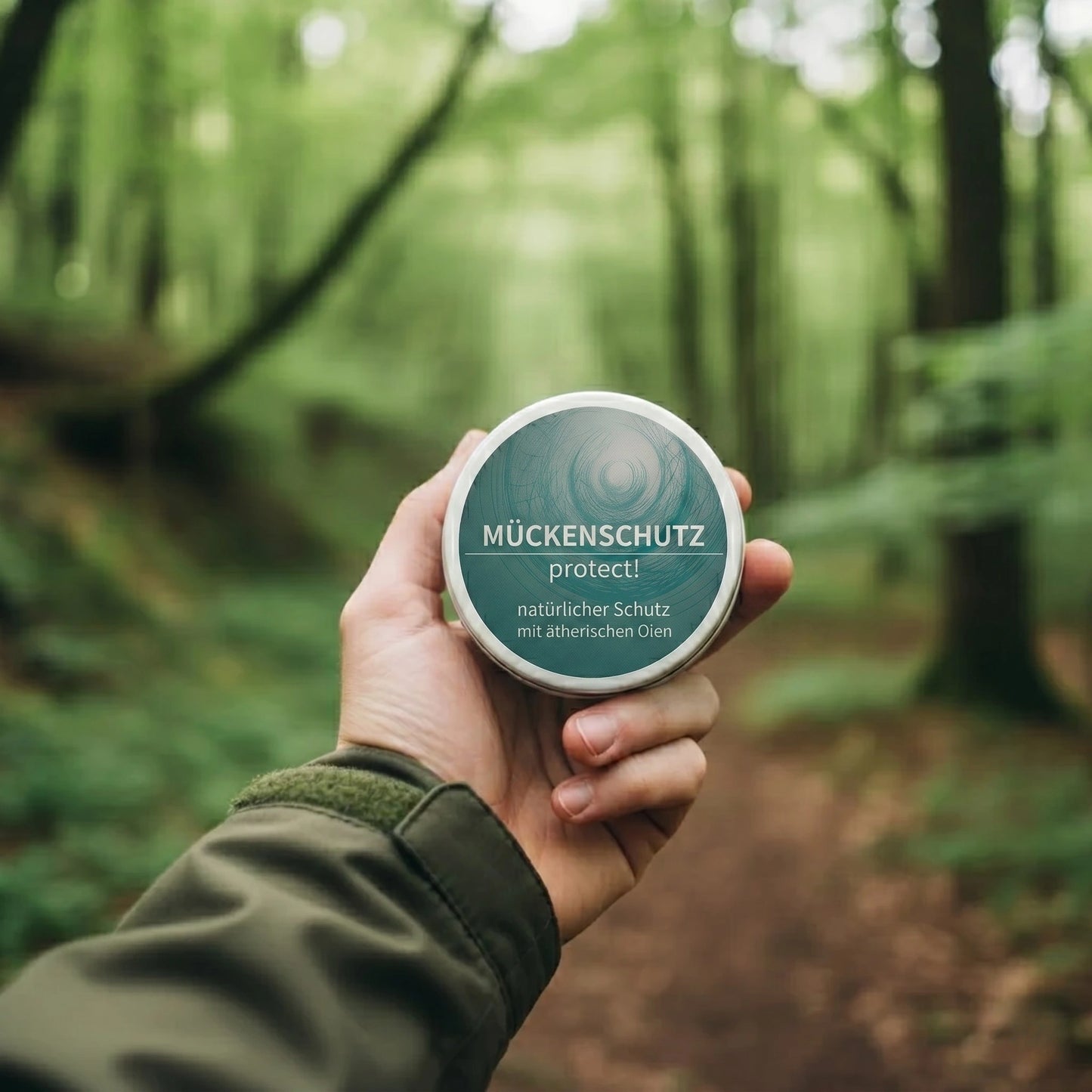 Ein natürlicher, fester Mückenschutz 'protect!' von Sonnengrün wird in der Hand vor einem nebligen Waldweg gehalten – ideal für Wanderungen und Camping.