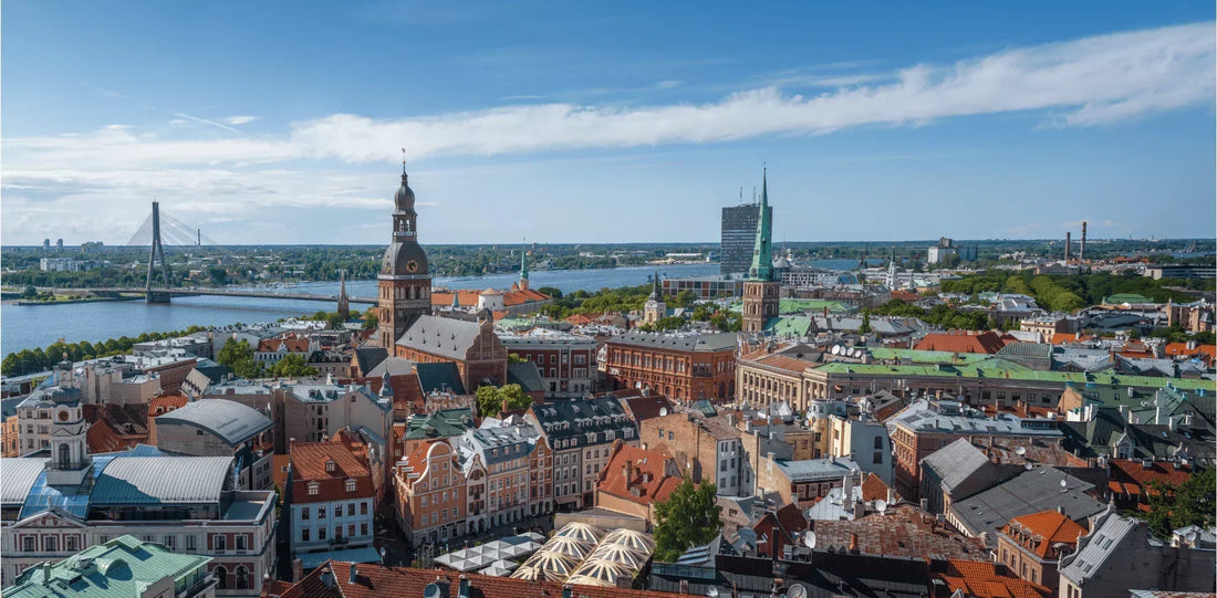 Panorama-Luftaufnahme der Altstadt von Riga, Lettland, bei Sonnenschein, mit Blick auf den Rigaer Dom, den Fluss Daugava und die Dächer der Stadt.