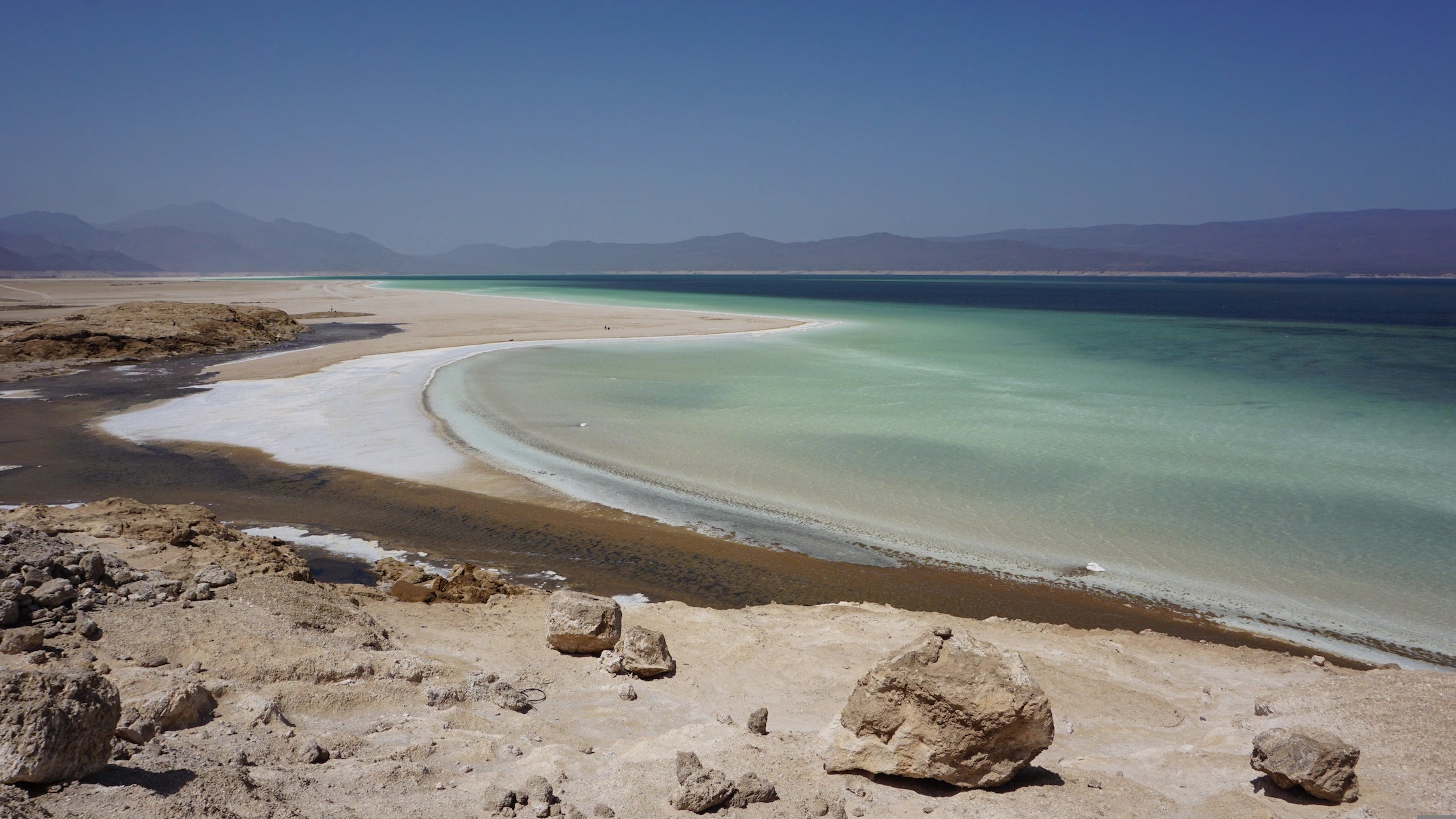 Weiße Salzufer und tiefblaues Wasser des Lac Assal, Dschibuti.