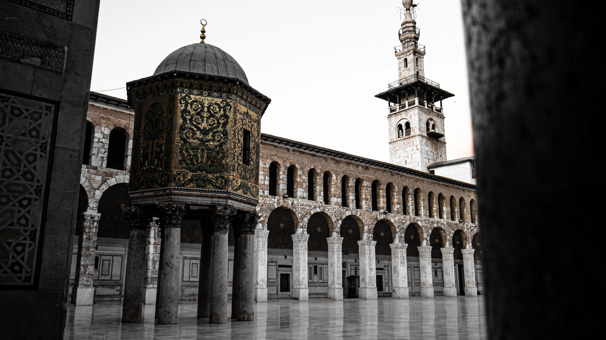Blick in den Innenhof der Umayyaden-Moschee in Damaskus mit dem auf Säulen stehenden, verzierten Schatzdom (Qubbat al-Khazna) und dem Jesus-Minarett im Hintergrund.