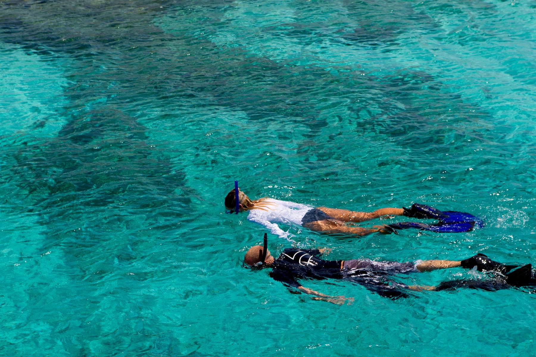Schnorchlerin über einem Korallenriff im klaren türkisen Wasser der Bahamas.